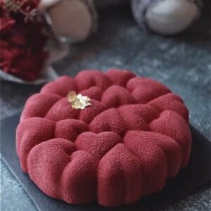 Decadent strawberry mousse cake with a vibrant red hue with velvet texture.